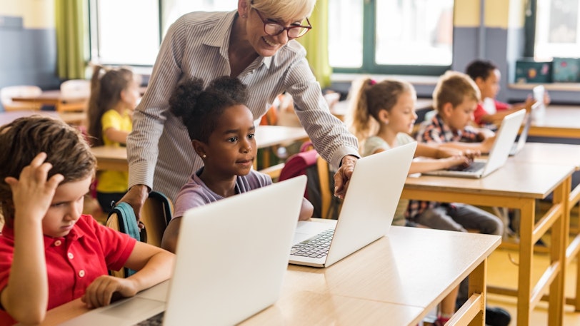 Standards Ed Leaders Stock Teacher and students on computers 1 1048099316